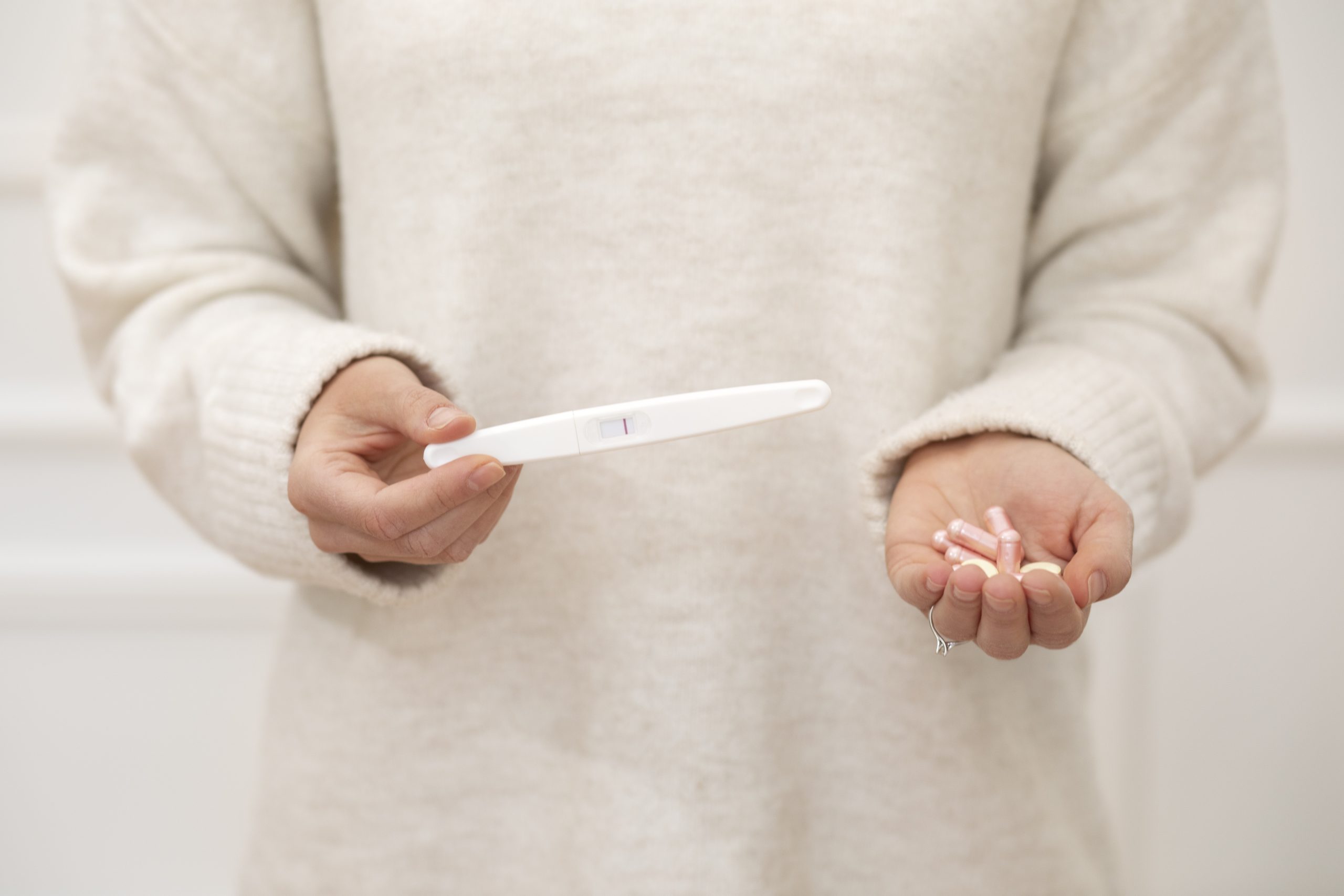 Woman planning pregnancy holding folic acid supplements as part of preconception health care