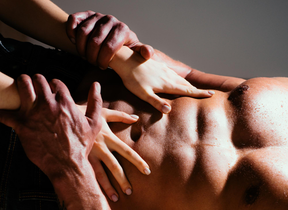 Hands gliding slowly along the body with soft natural light, representing varied rhythm, gentle touch, and anticipation in sensual massage.